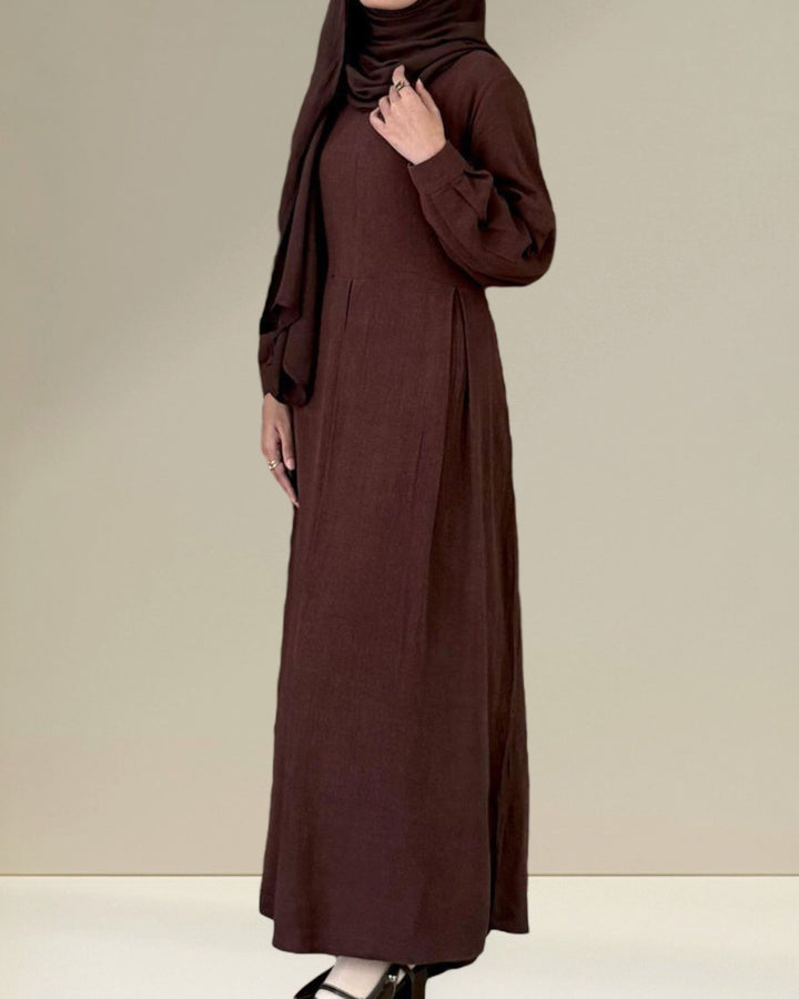 Brown dress with matching hijab on a plain background